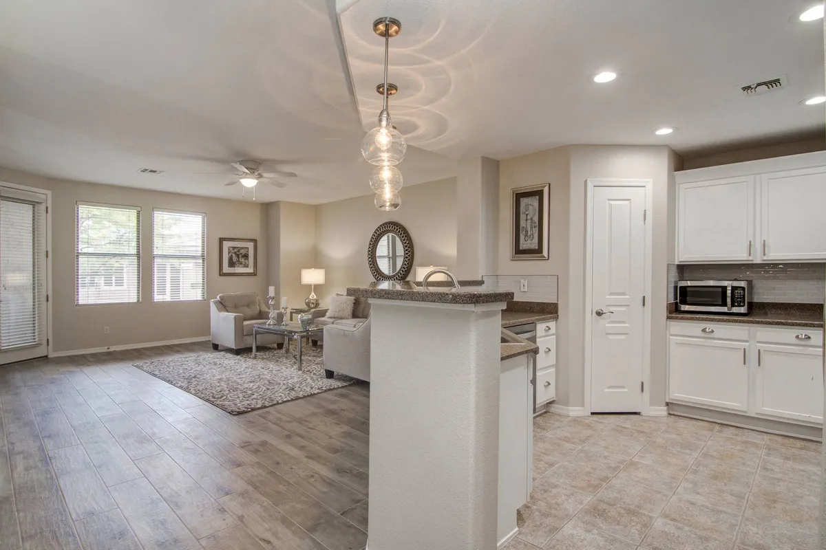 The image features an inviting open living area with comfortable seating and a view of the kitchen counter, illuminated by warm lighting. The atmosphere is cozy, ideal for social gatherings or family relaxation after a day out exploring local attractions.
