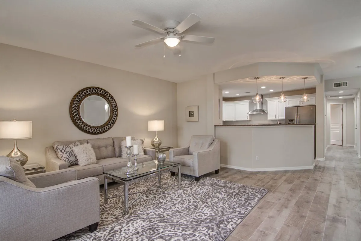 This interior shot features a cozy living room with a sofa, coffee table, mirror, and warm lighting fixtures. The scene suggests a welcoming atmosphere for relaxing, entertaining, or family gatherings, enhanced by subtle holiday decor cues.